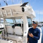Boat owner checking his phone below a Solace 4G camera mounted on his boat